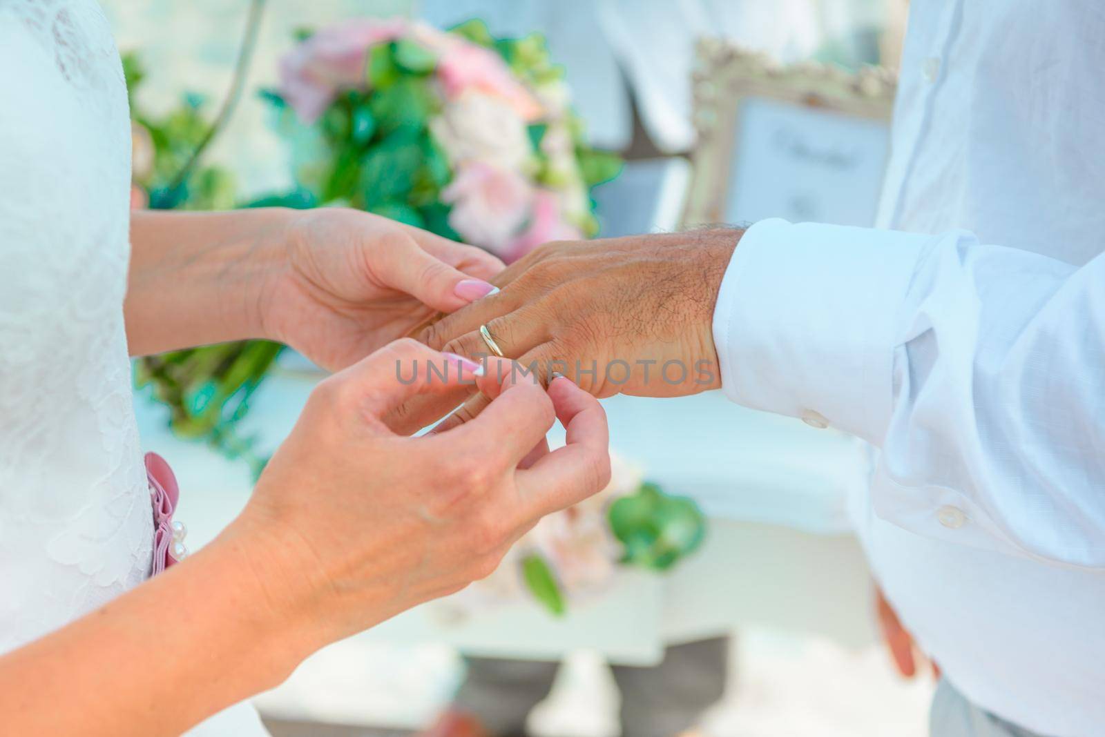 Hands of the newlyweds at the wedding ceremony of dressing the wedding rings, hands close-up.