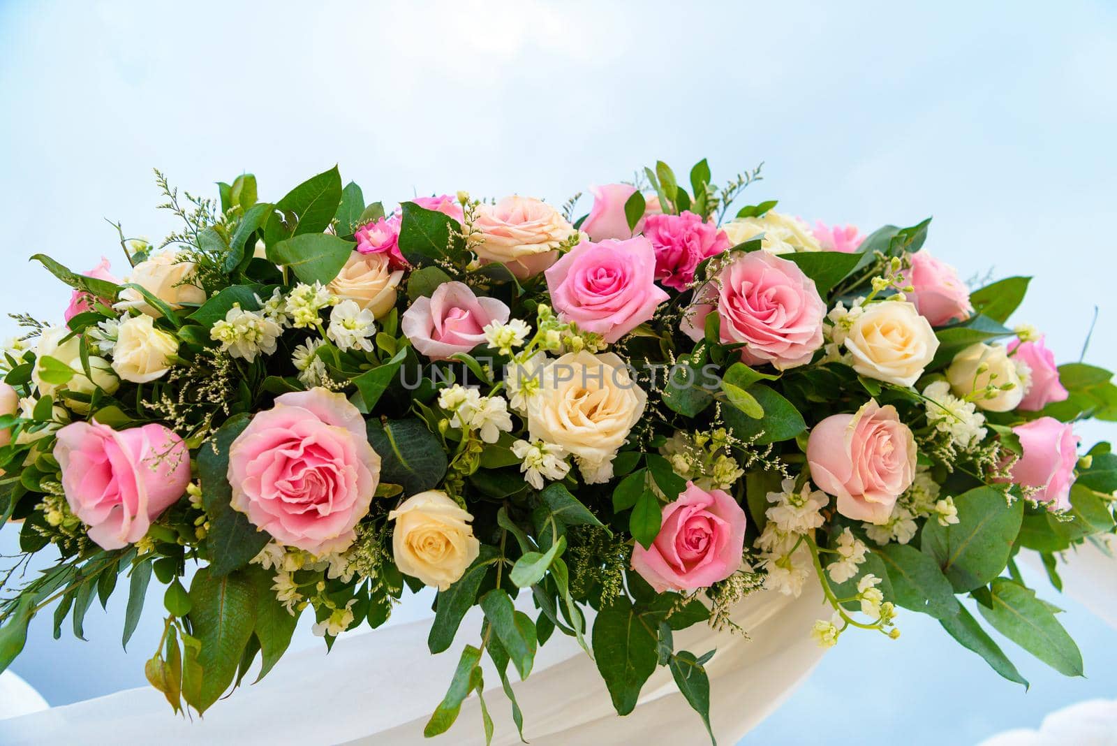 Scenery of flowers of white roses on a wedding arch.