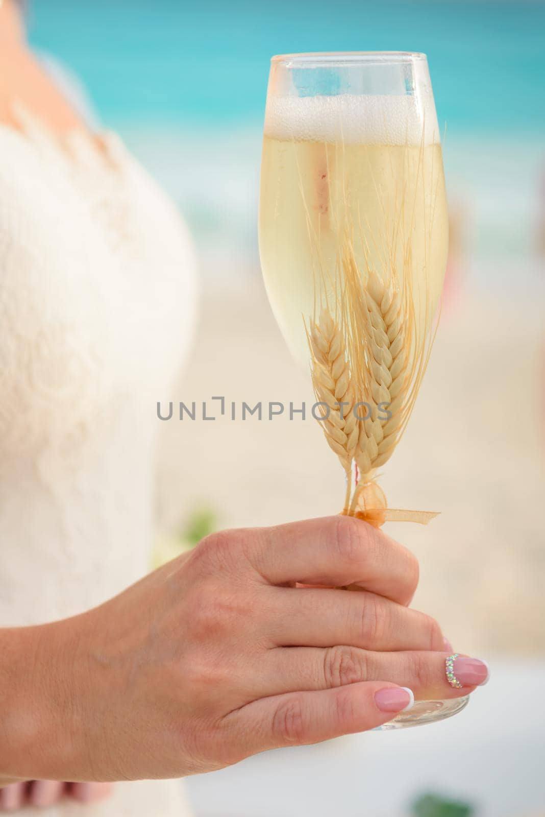 The bride holds in her hand a glass of champagne.