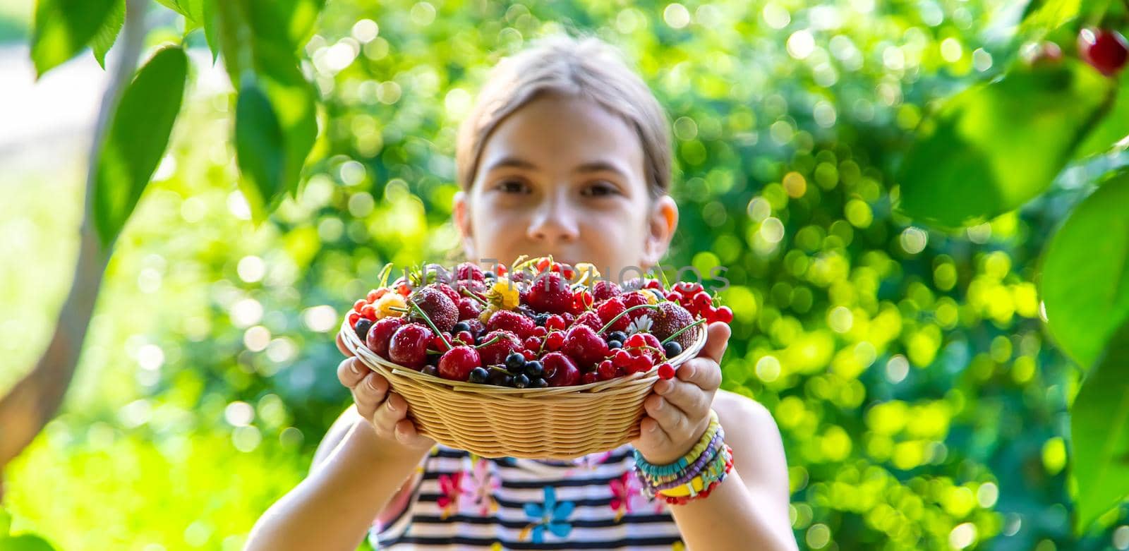 The child eats berries in the garden. Selective focus. by yanadjana