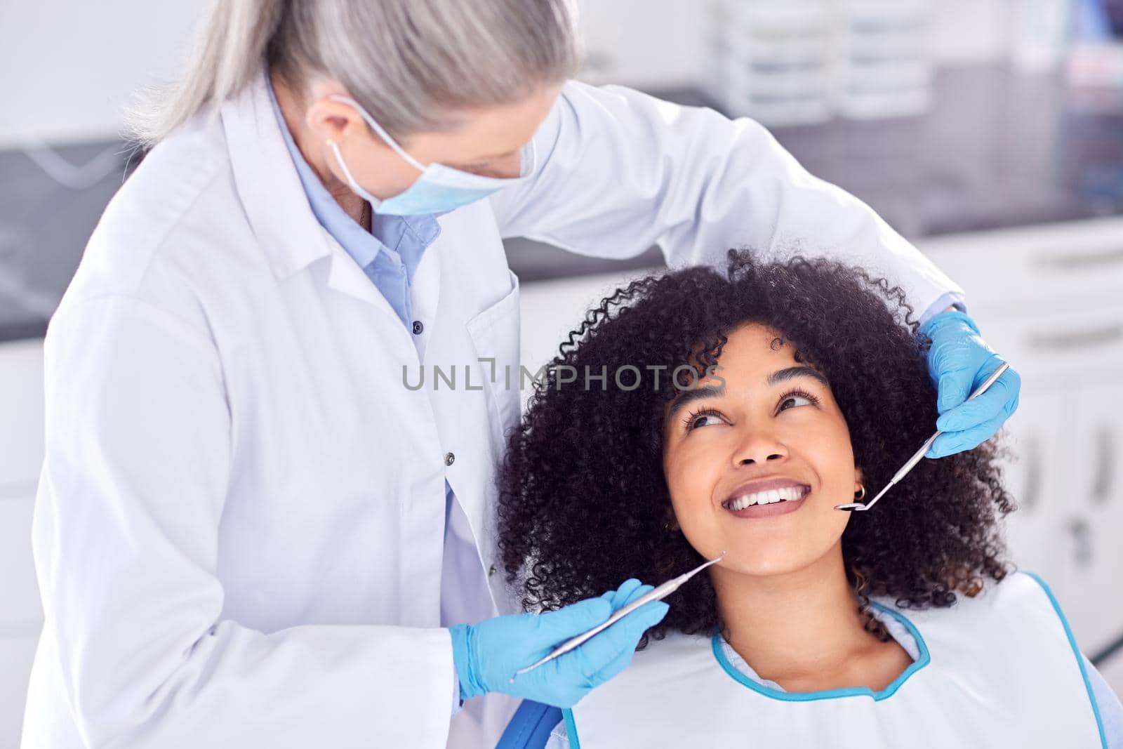 .. Shot of a young female patient having her teeth examined at the dentist. by YuriArcurs