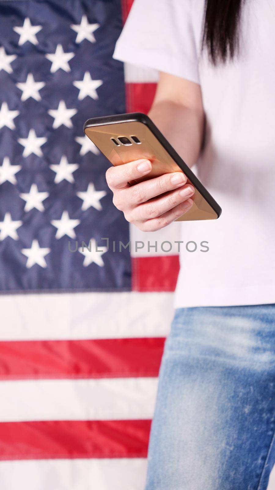 Hand holding and typing on mobile phone United states of America flag on background. Mockup phone. Social, communication, Labor day, 4th of July, Memorial day, 9.11. by JuliaDorian