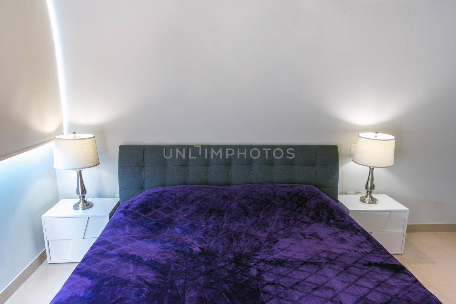 Double-bed with a violet coverlet in the interior