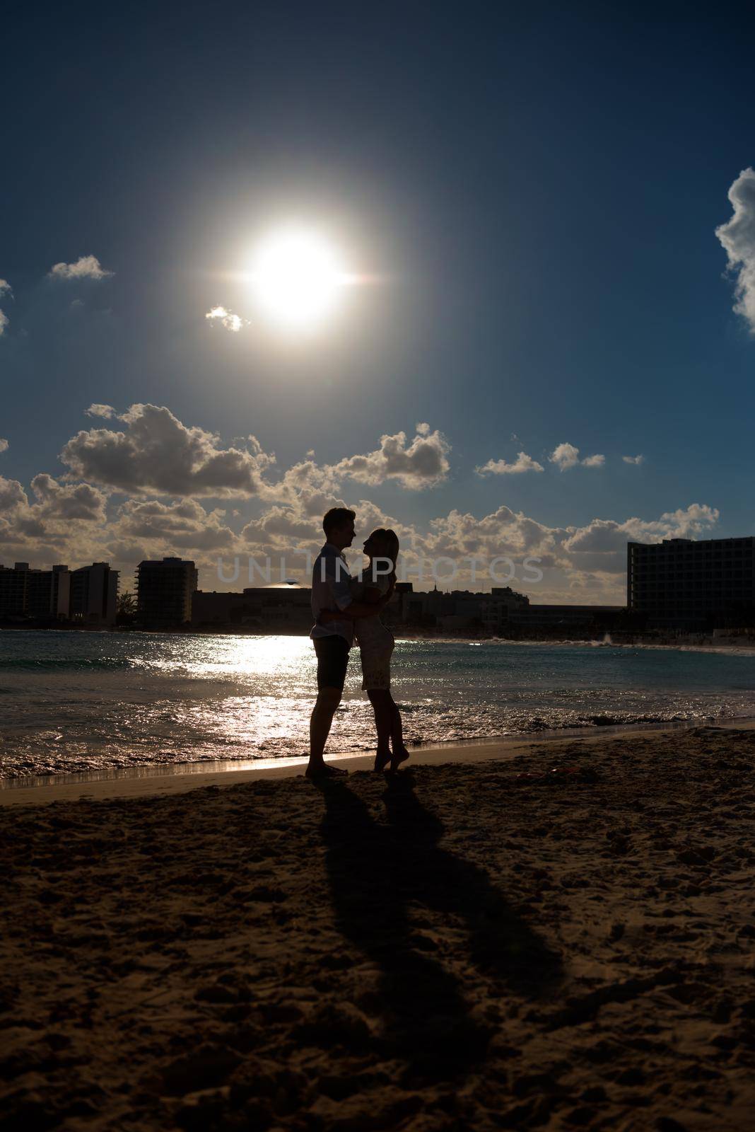 Silhouettes of men and women against the backdrop of the setting sun