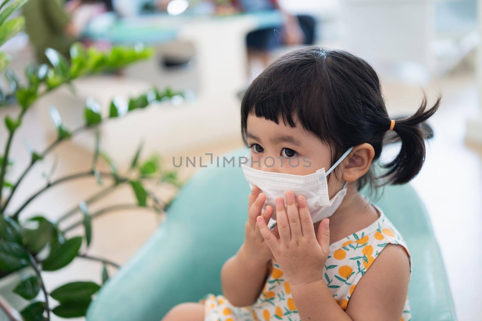 Asian girl wearing a mask sitting in the living room, Covid-19 situation prevention of covid health care Prevent infection with the covid 19 virus.