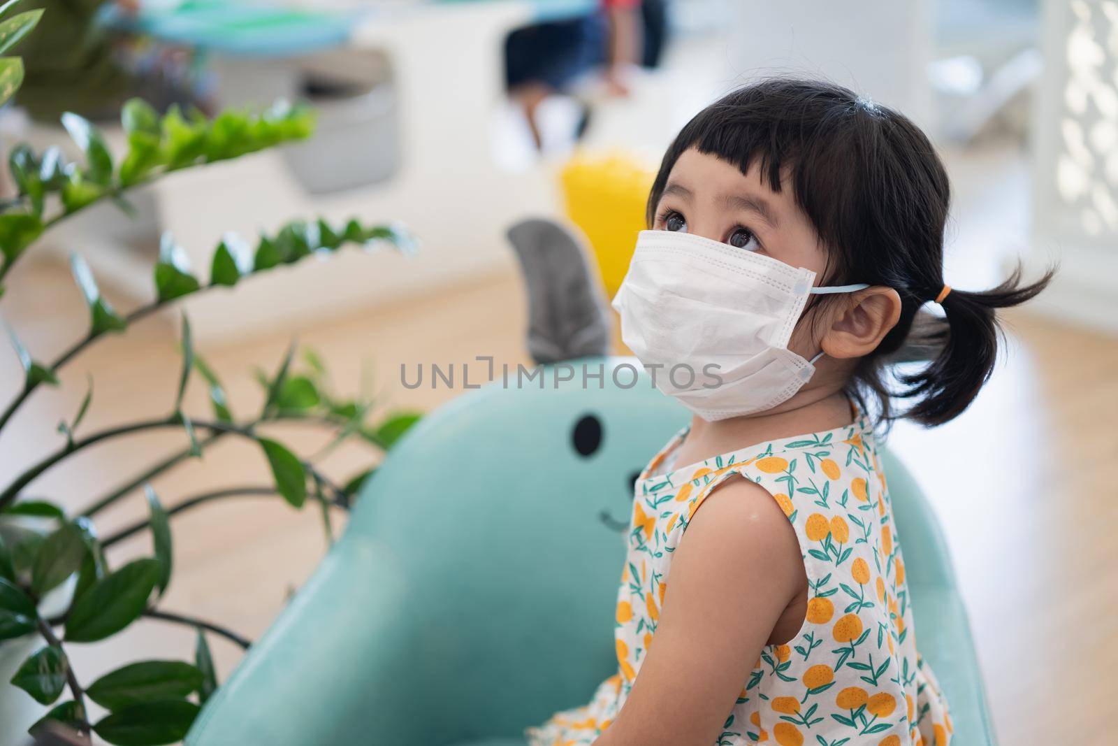 Asian girl wearing a mask sitting in the living room, Covid-19 situation prevention of covid health care Prevent infection with the covid 19 virus. by Wmpix