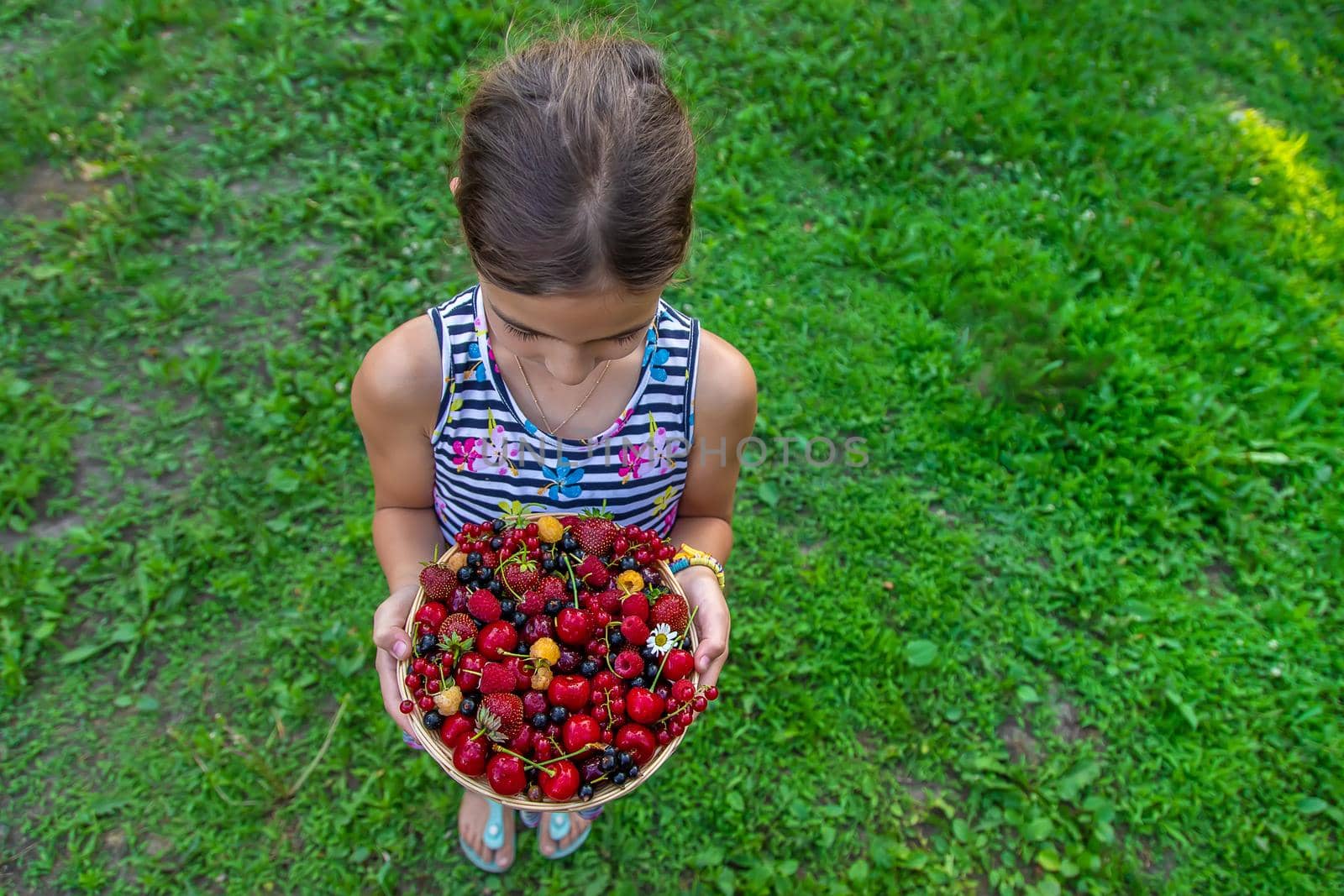 The child eats berries in the garden. Selective focus. by yanadjana