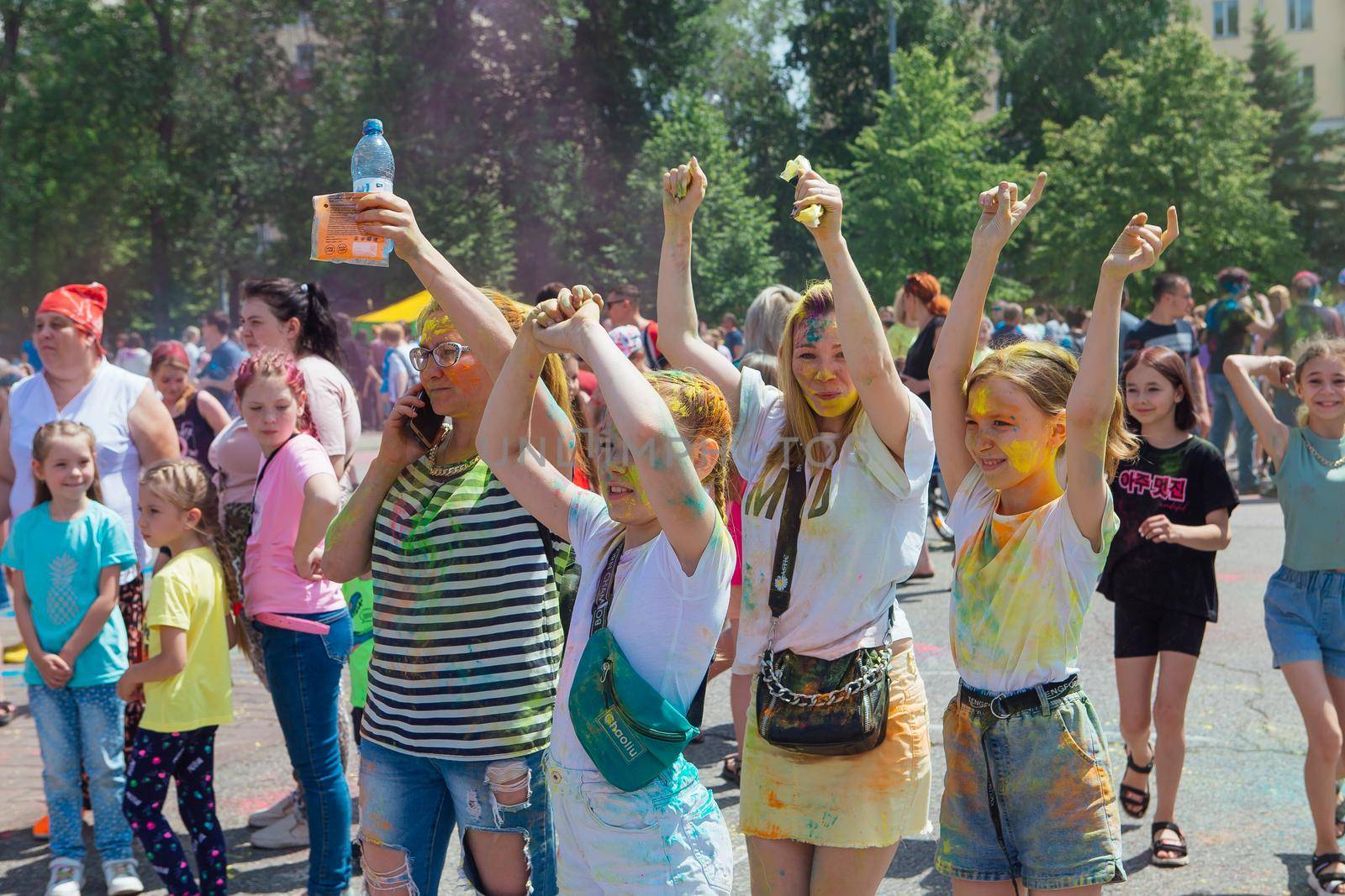 Novokuznetsk, Kemerovo region, Russia - June 12, 2022 :: Children with colorful faces painted with holi powder having fun outdoors.