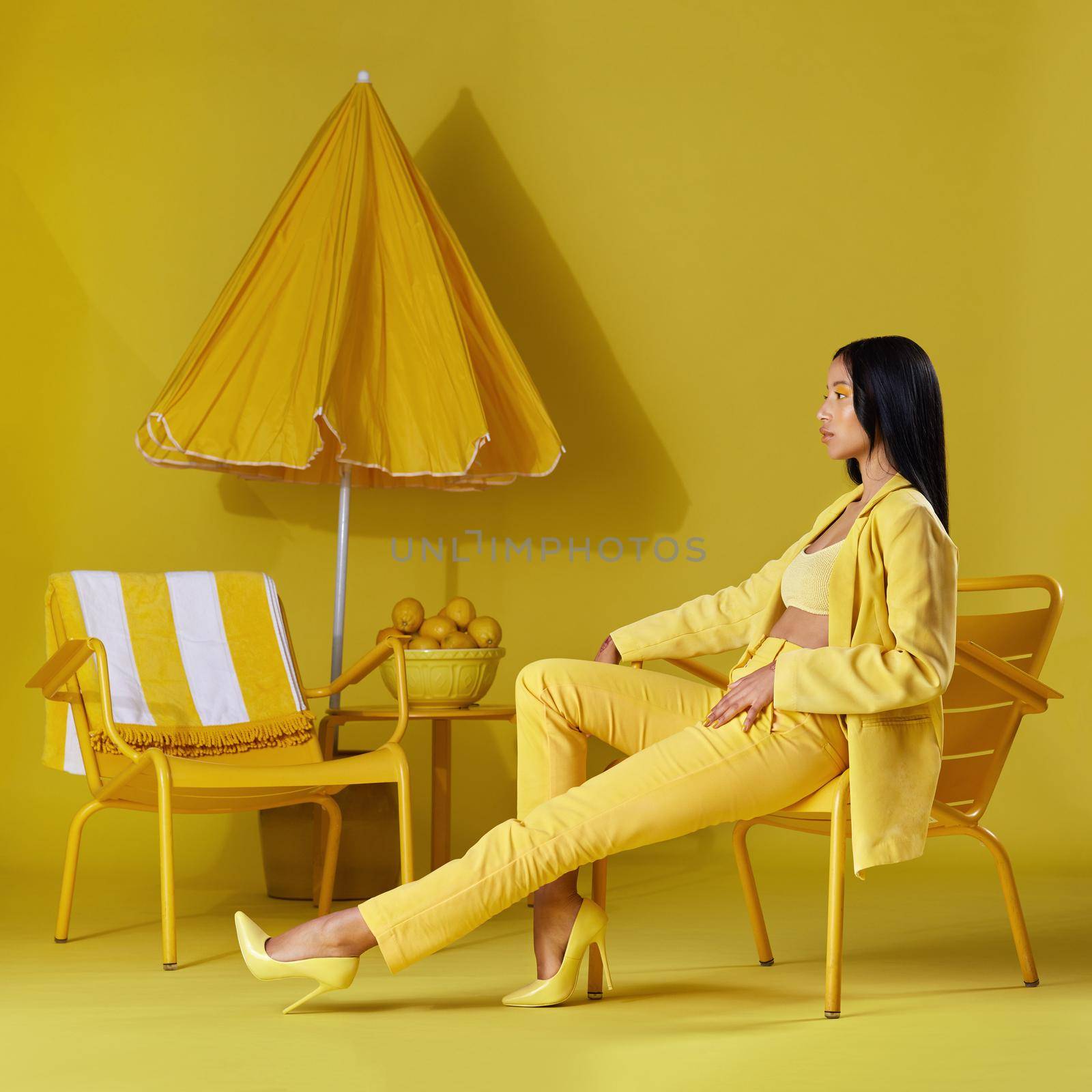 They call me mellow yellow. Studio shot of a young woman dressed in stylish yellow clothes against a yellow background. by YuriArcurs