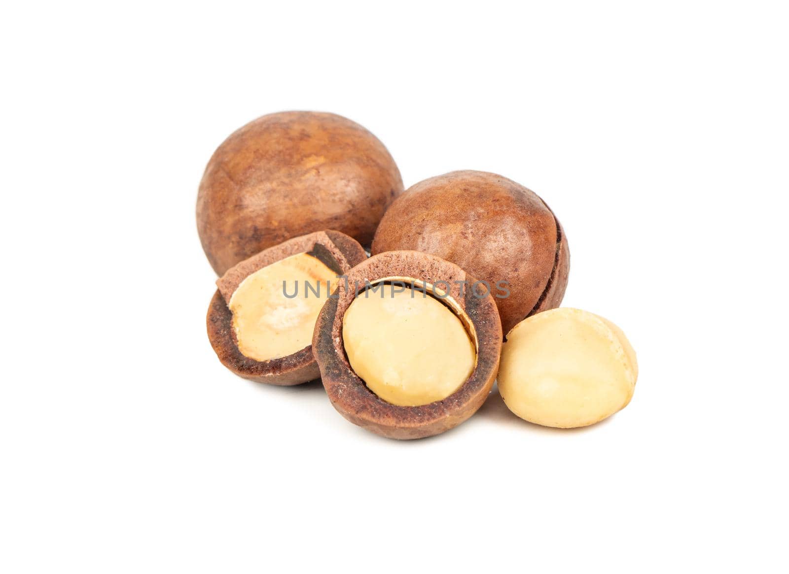 Split macadamia nuts with whole ones on a white background