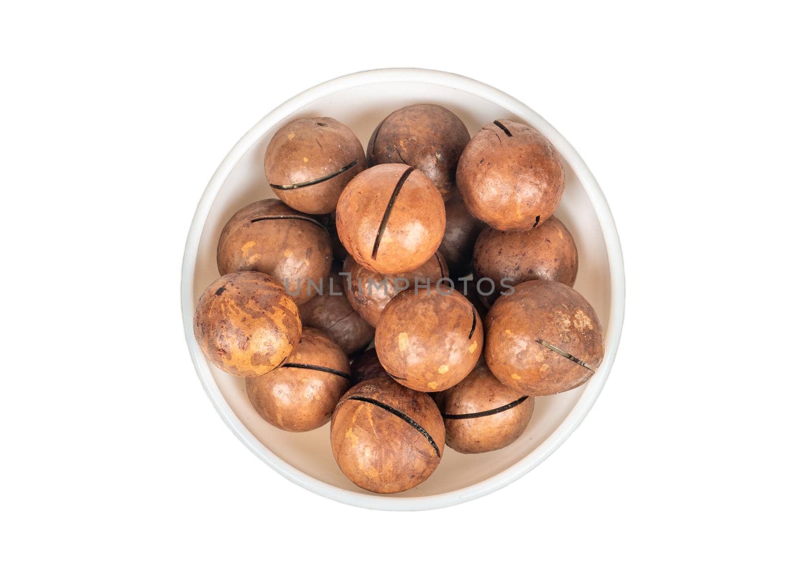 Macadamia nut in a ceramic bowl on a white background, top view