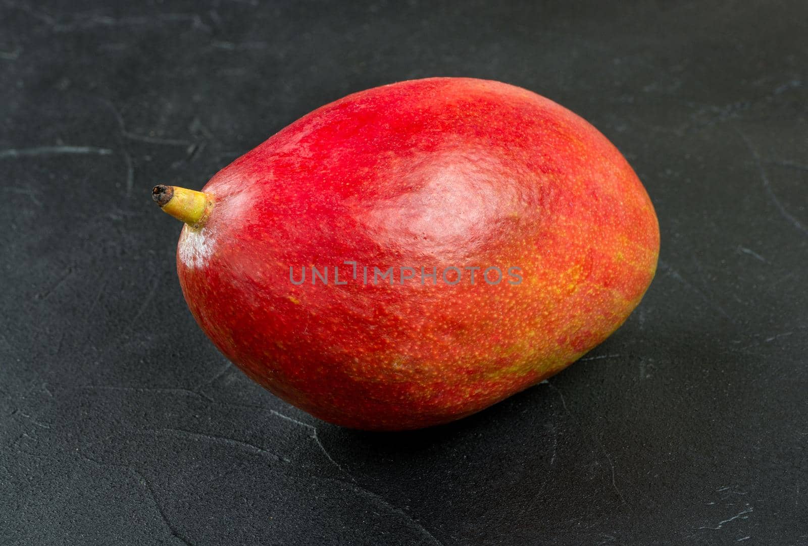 Red ripe mango fruit on a dark background
