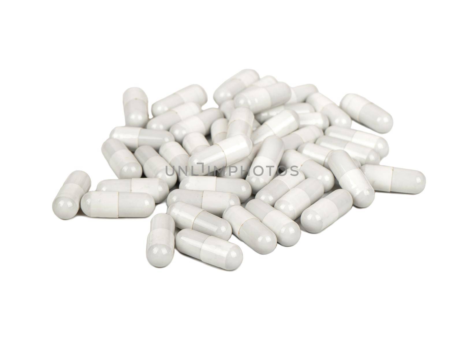 Pile of scattered gray capsules on a white background