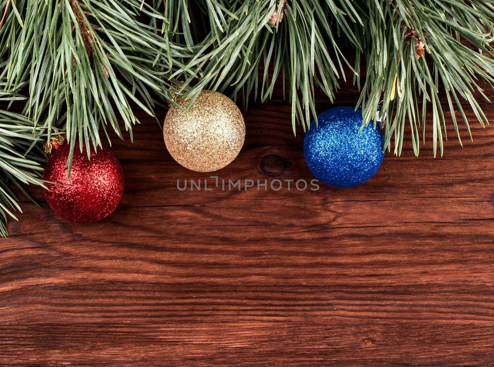 Branches of pine with Christmas toys on a wooden table