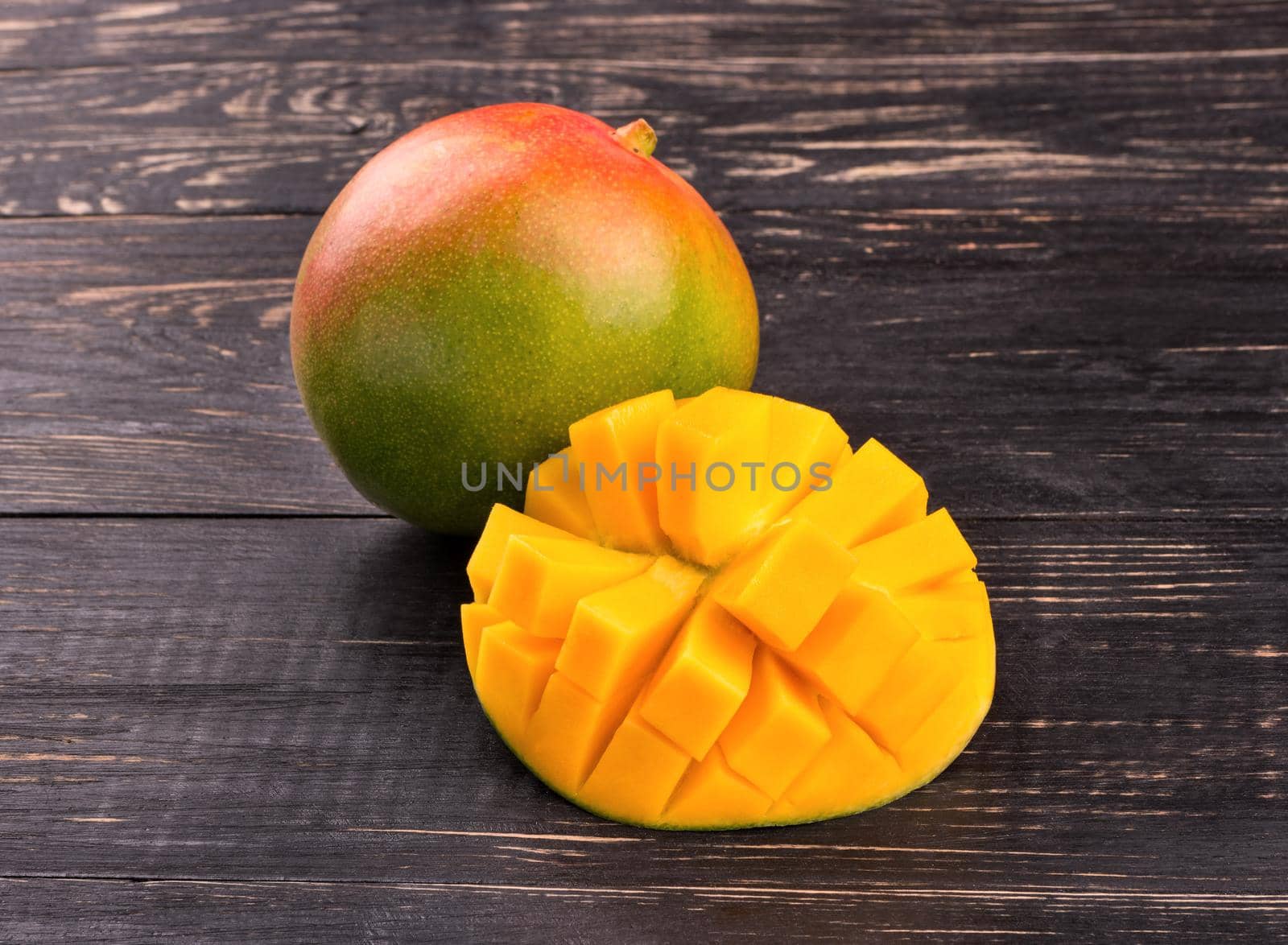Fresh mango fruit with half cut into pieces on the table