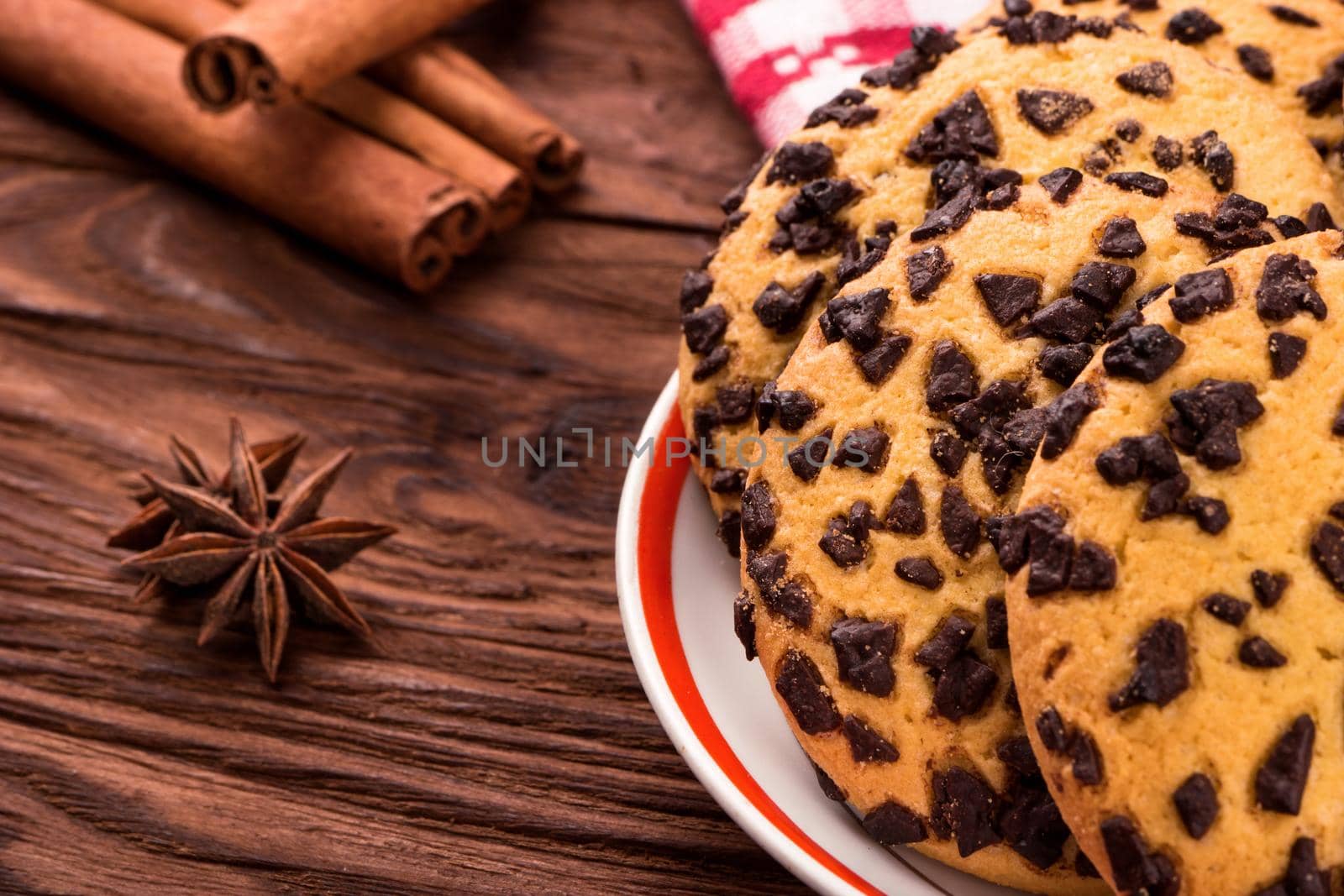 Cookies with chocolate on a plate with spices on a table close-up