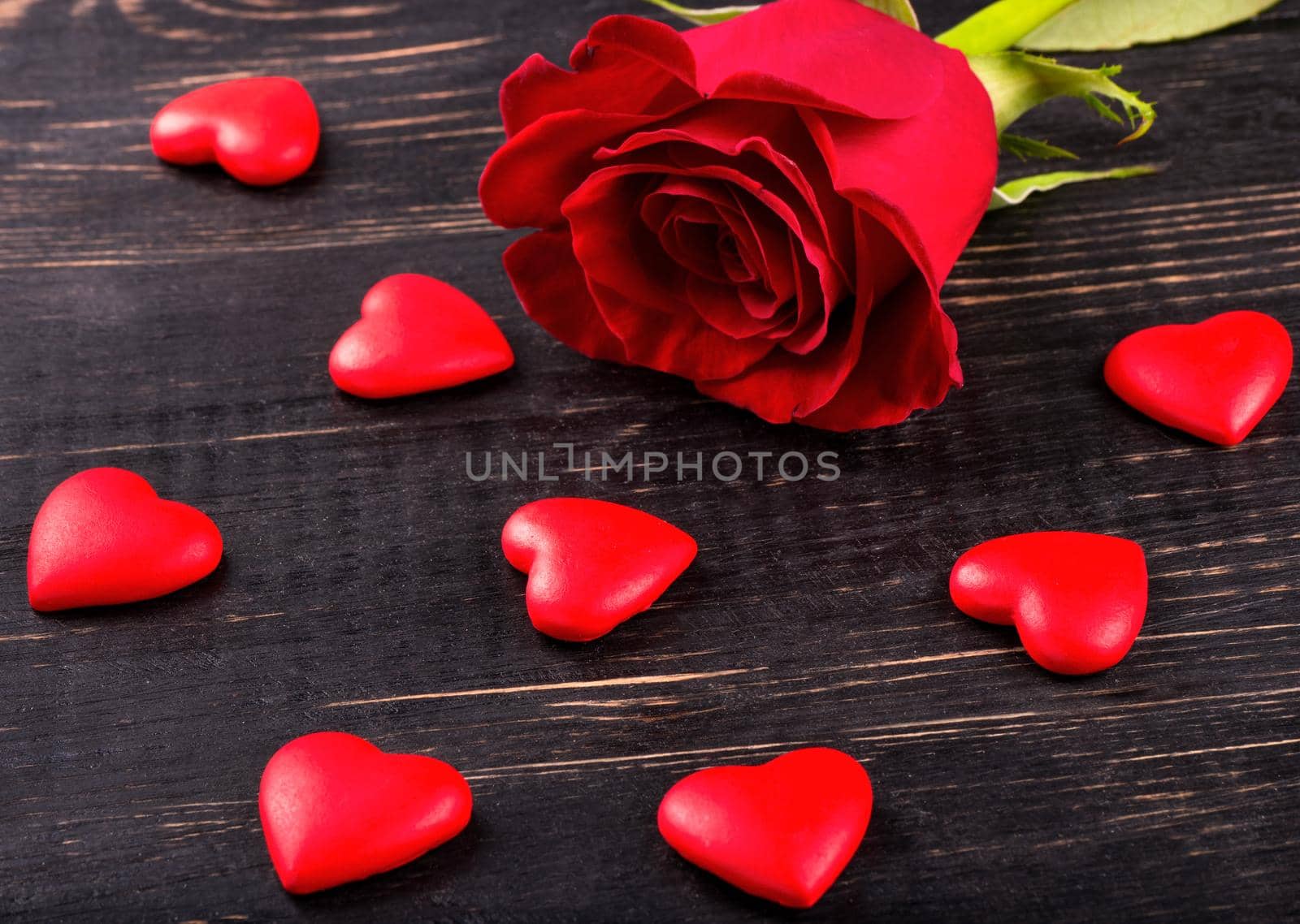 Scattered hearts with a red rose symbolizing valentines day