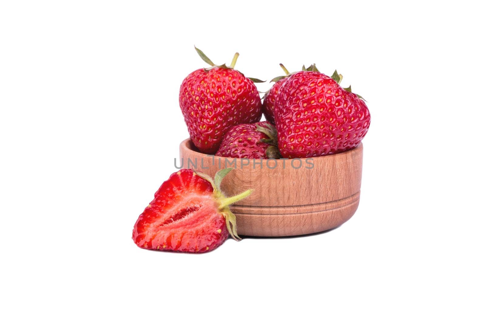 Ripe fresh strawberries in a small wooden bowl on a white background
