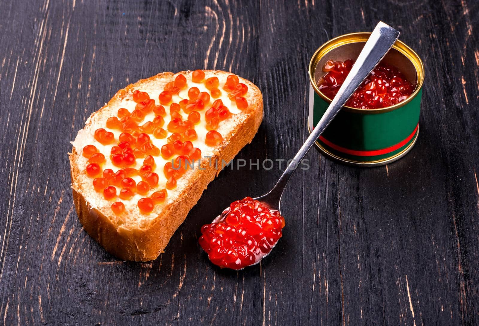 Preparation of sandwiches with red salmon caviar on a table
