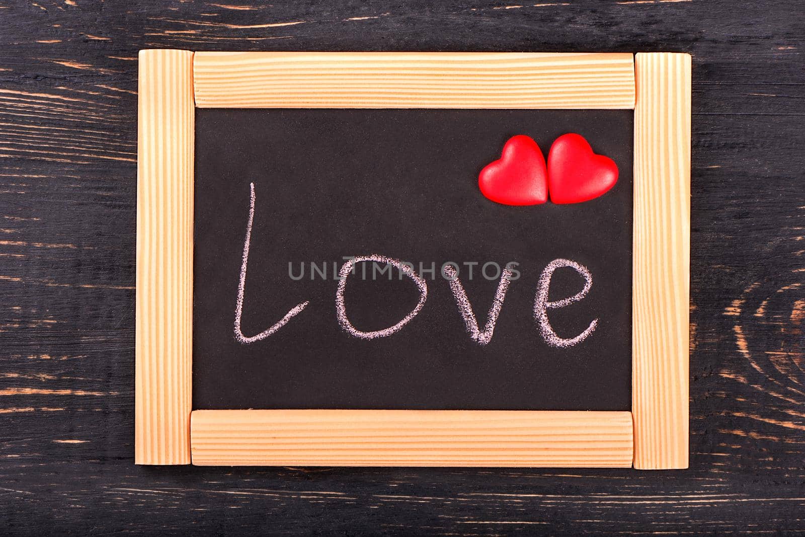 Board with a frame with the word love and two hearts symbolizing valentines day