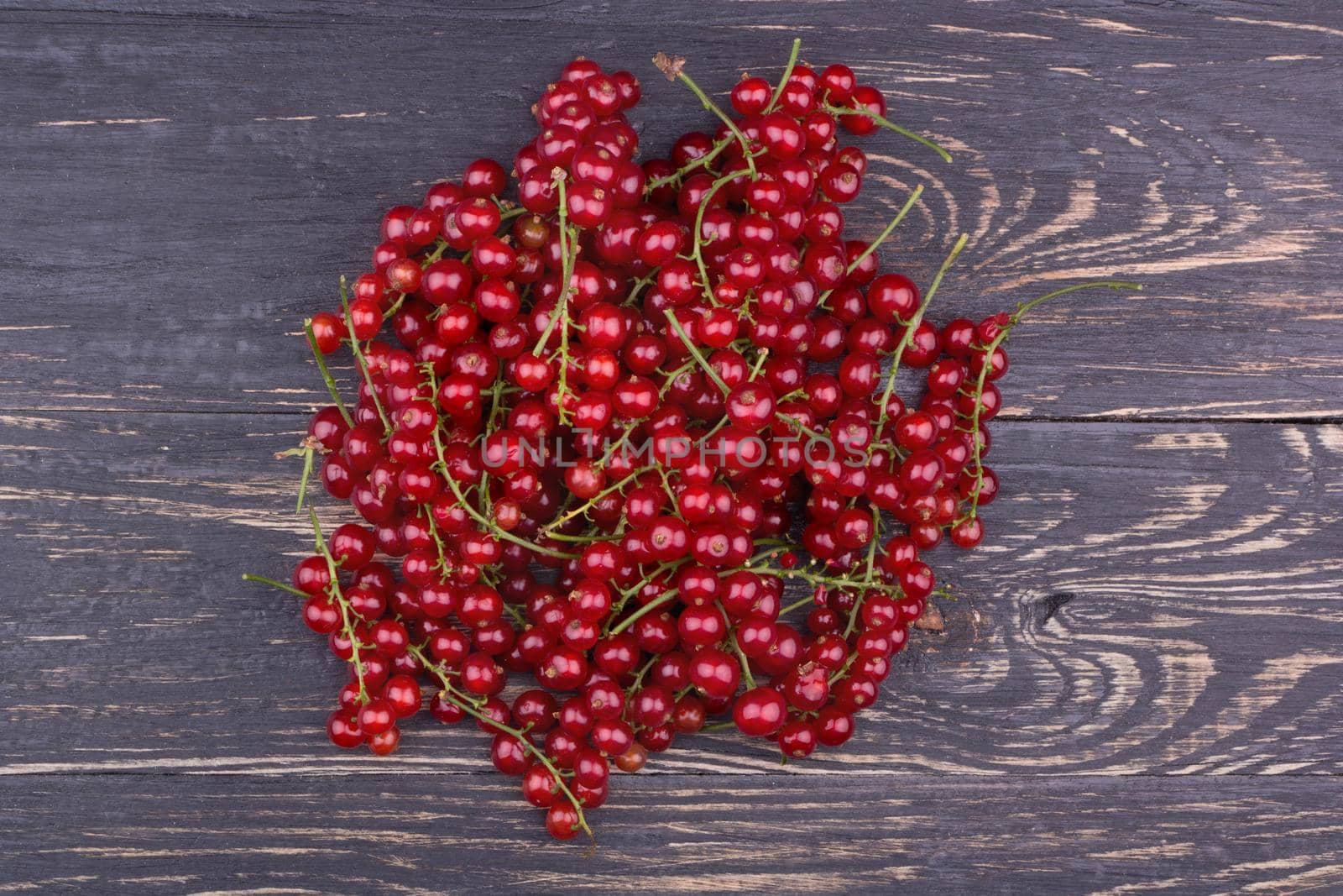 A pile fresh redcurrant on a dark wooden background
