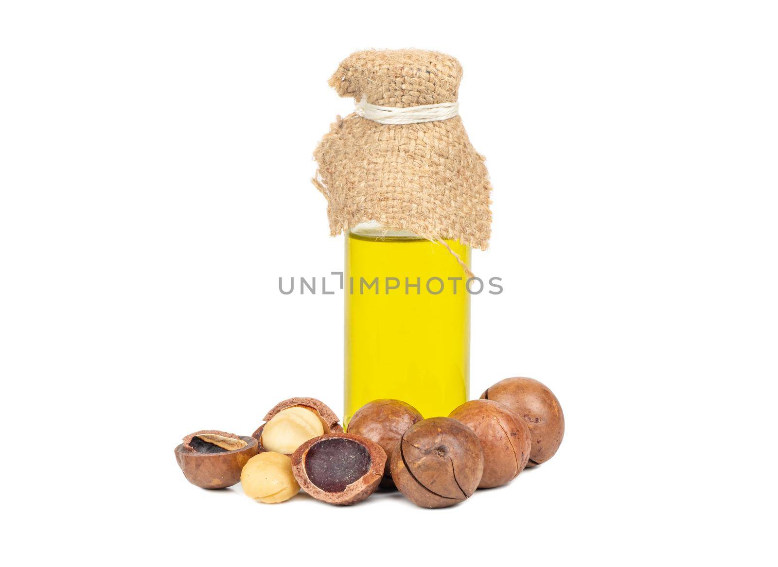 Macadamia nuts with oil in a bottle on a white background