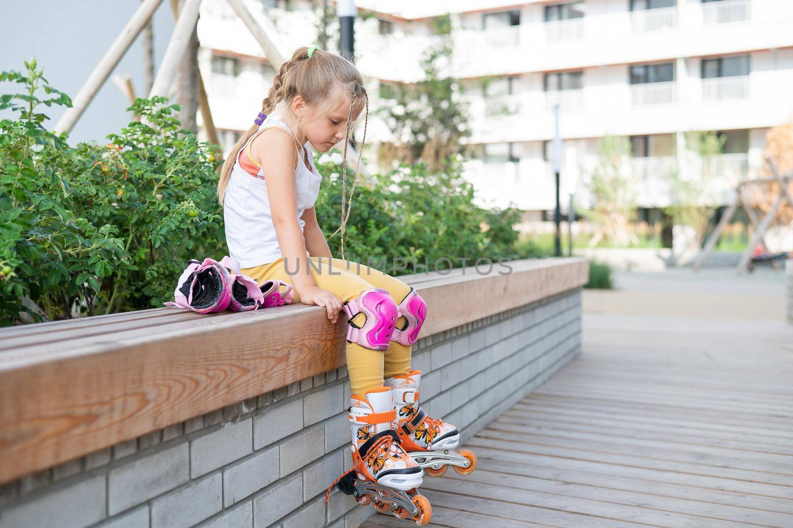 Little girl learns to roller skate outdoors