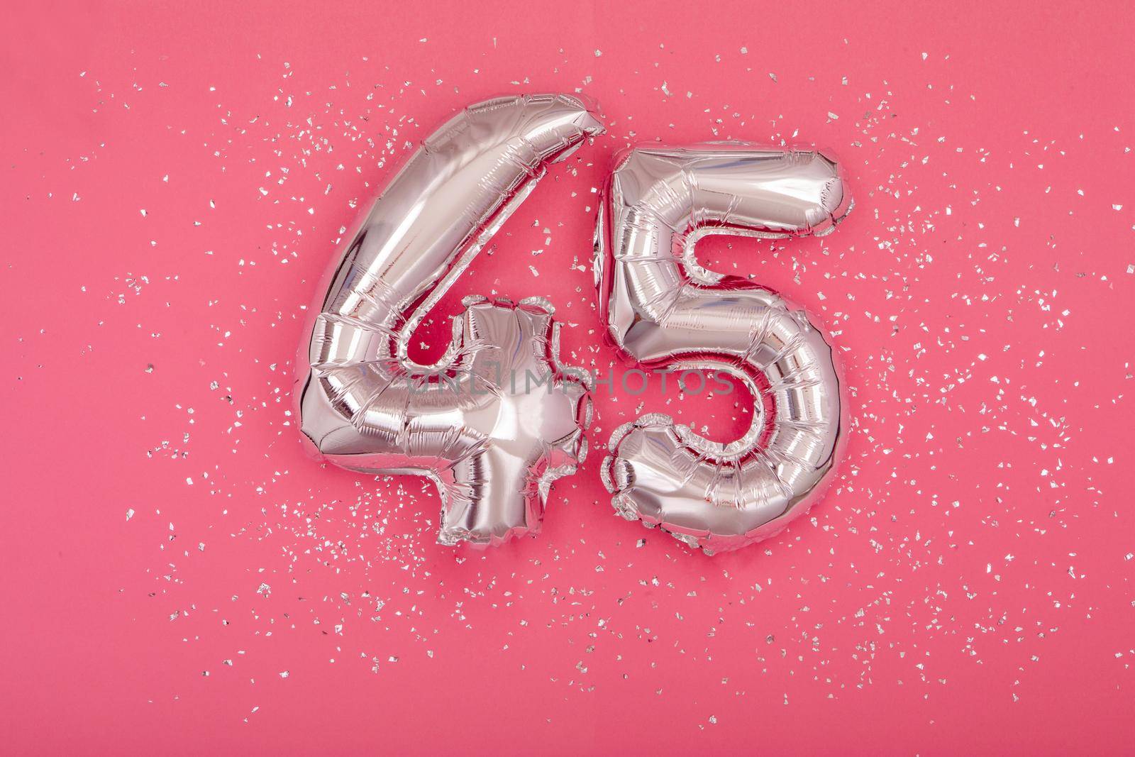 Silver balloon shape of number fourty five 45 pink background by Demkat