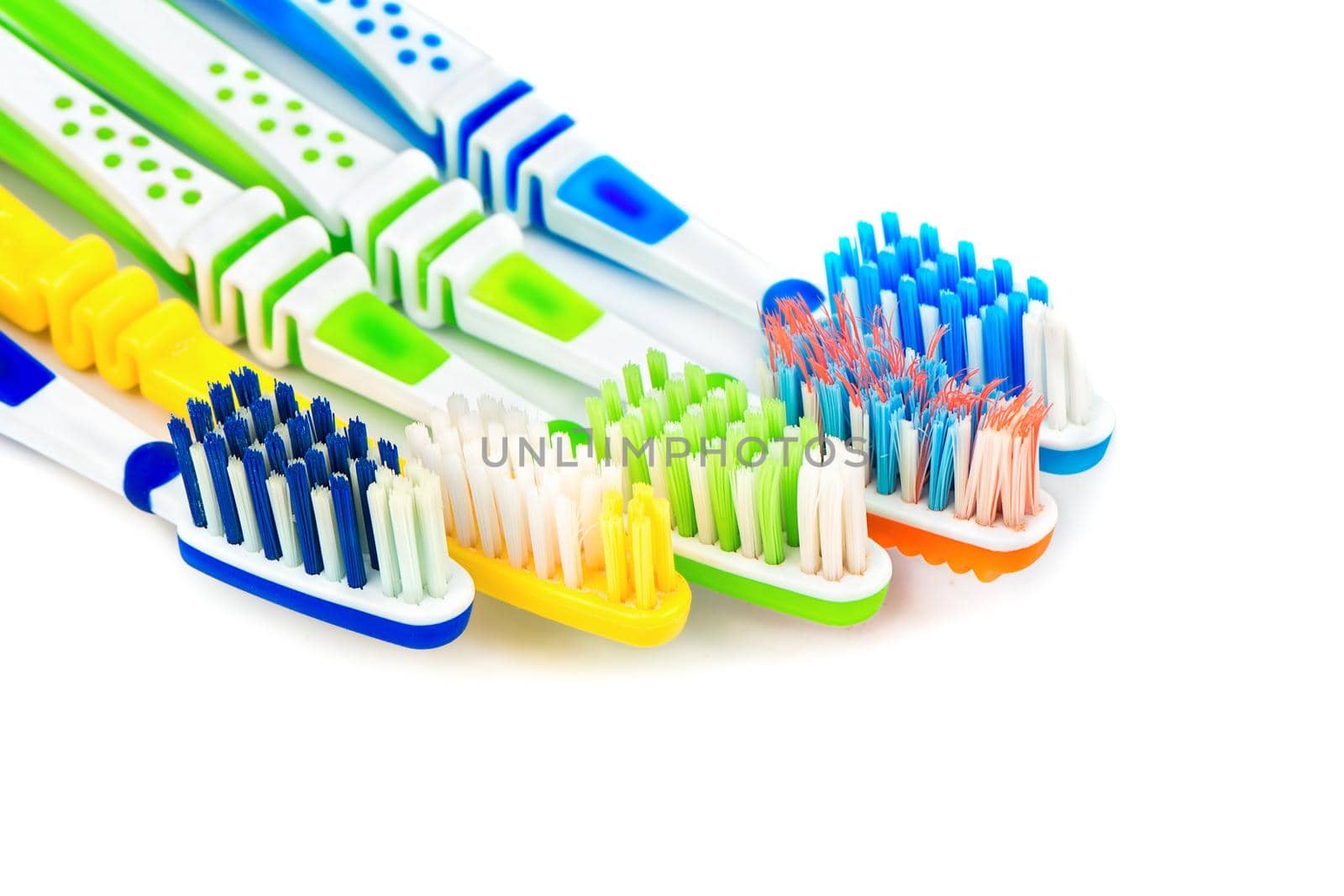 Several multi-colored toothbrushes on a white background closeup