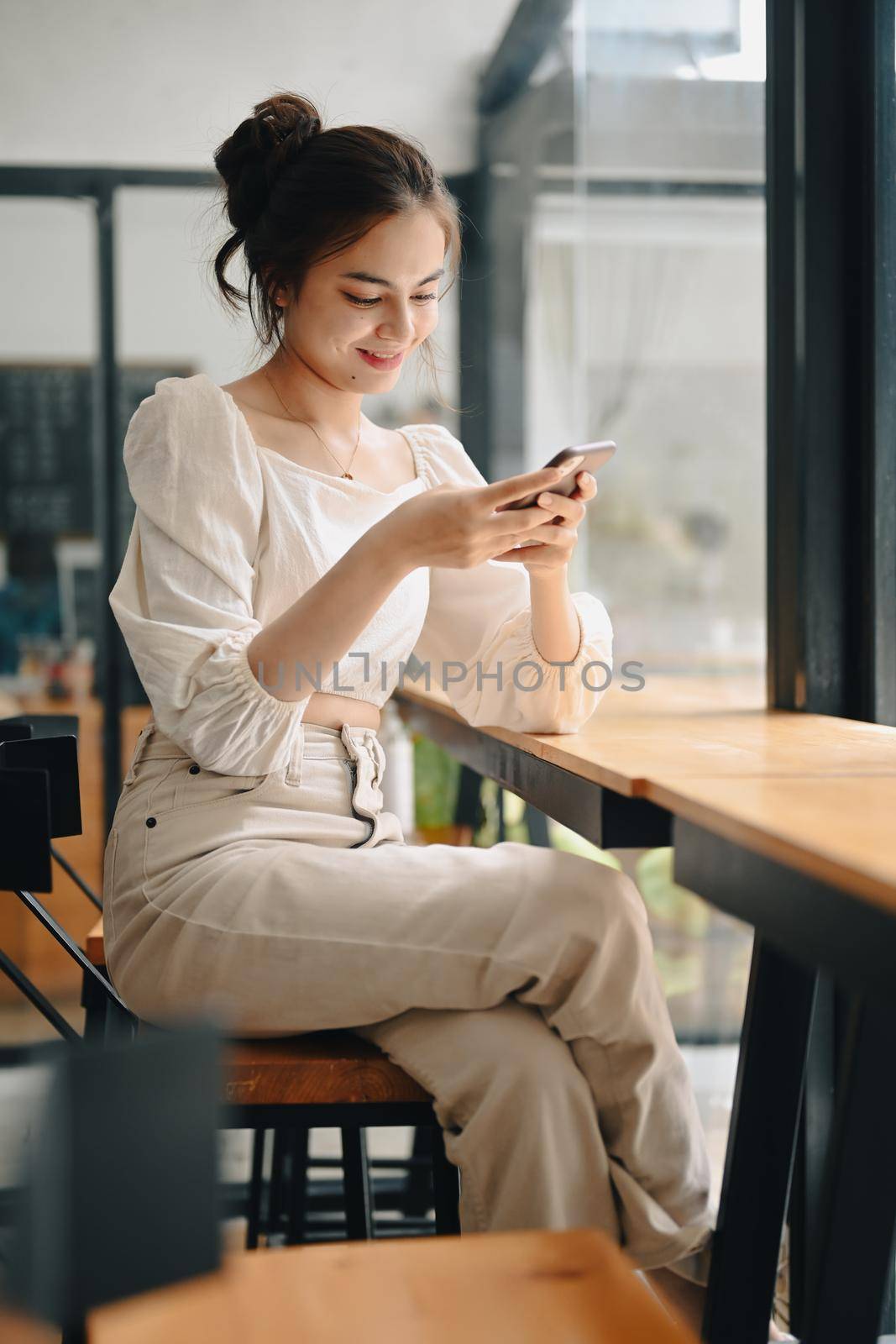 Beautiful young woman using mobile phone, commenting in online community.