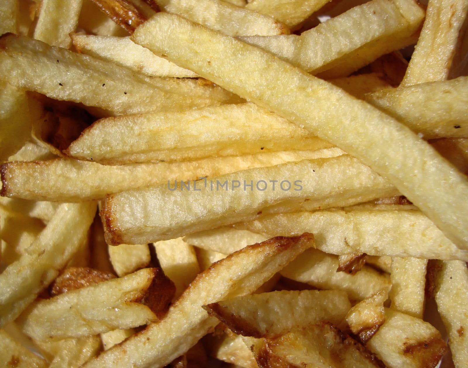 Close up of American Fast food style fresh french fries light sprinkling of salt and pepper