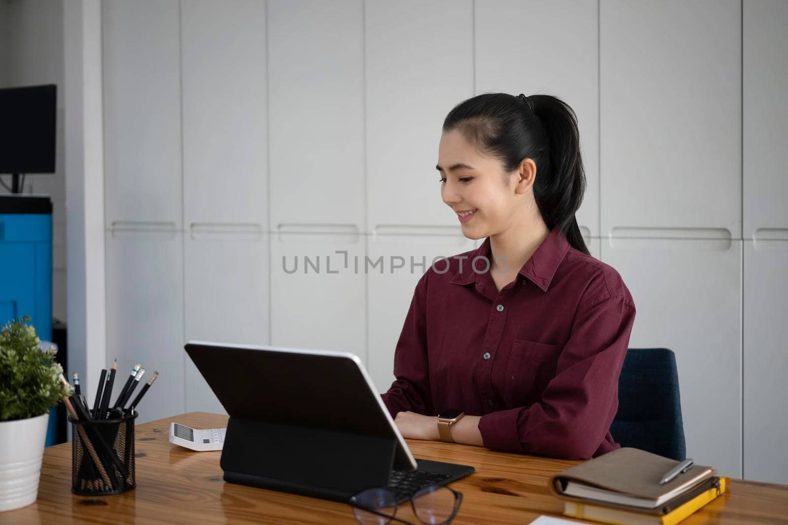Attractive asian businesswoman working with computer tablet in her office room.