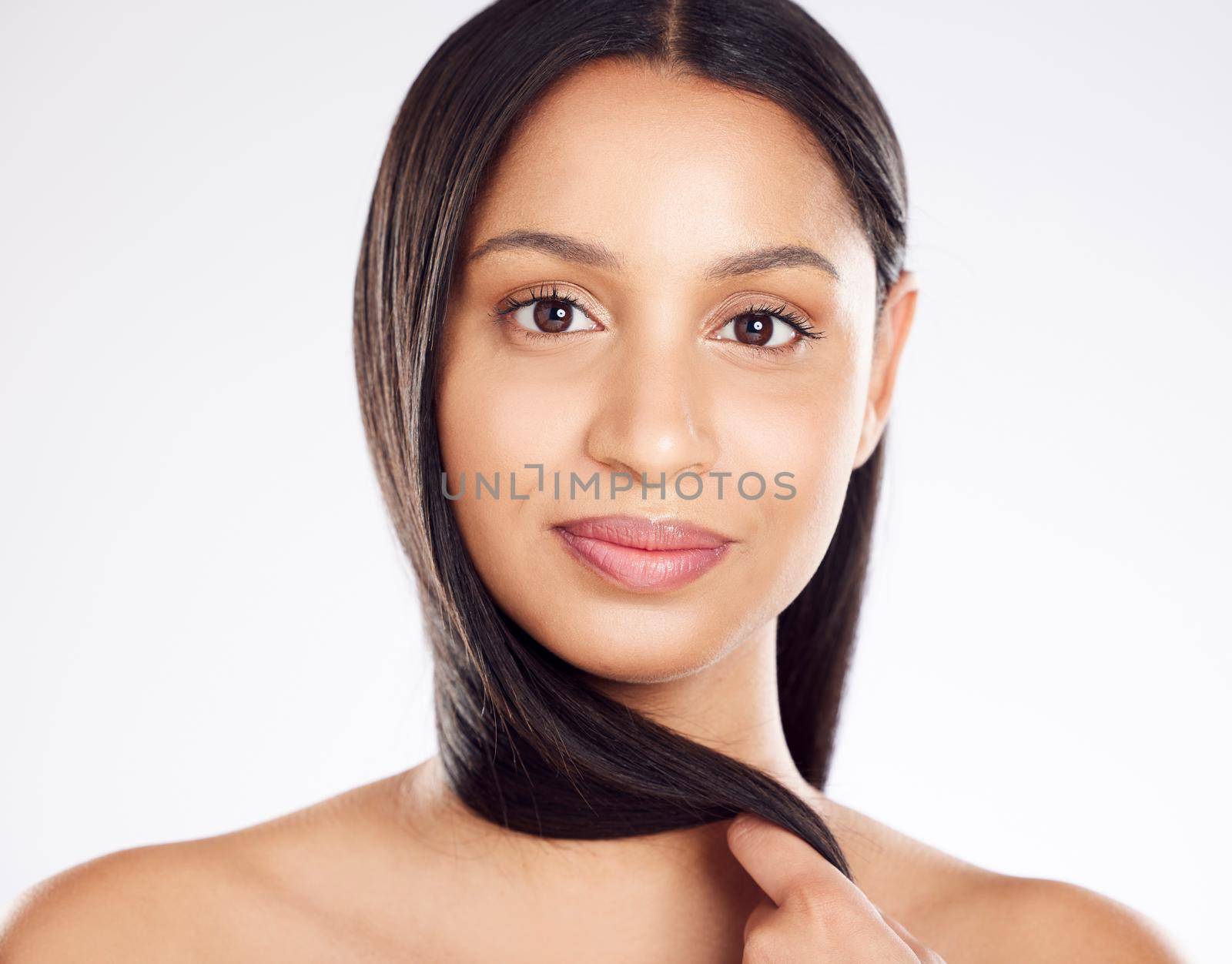 Shot of a young woman posing against a white background with healthy looking hair.