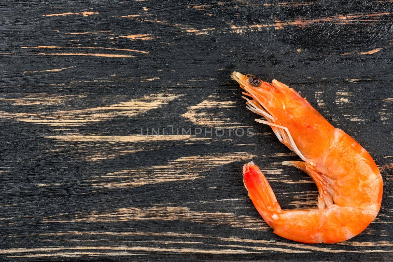 Boiled shrimp on an empty wooden background, top view