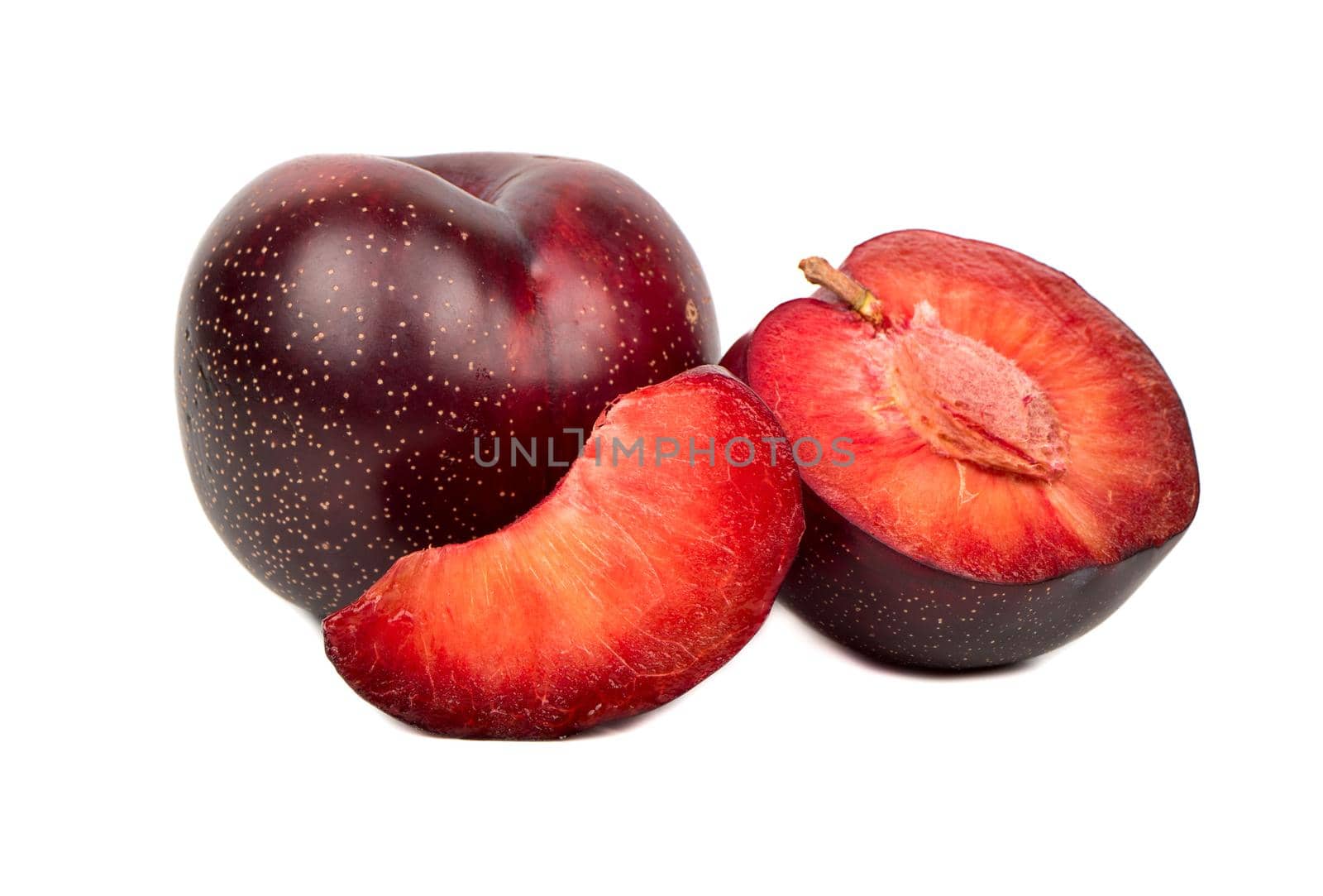 Ripe red plum with half and slice on white background