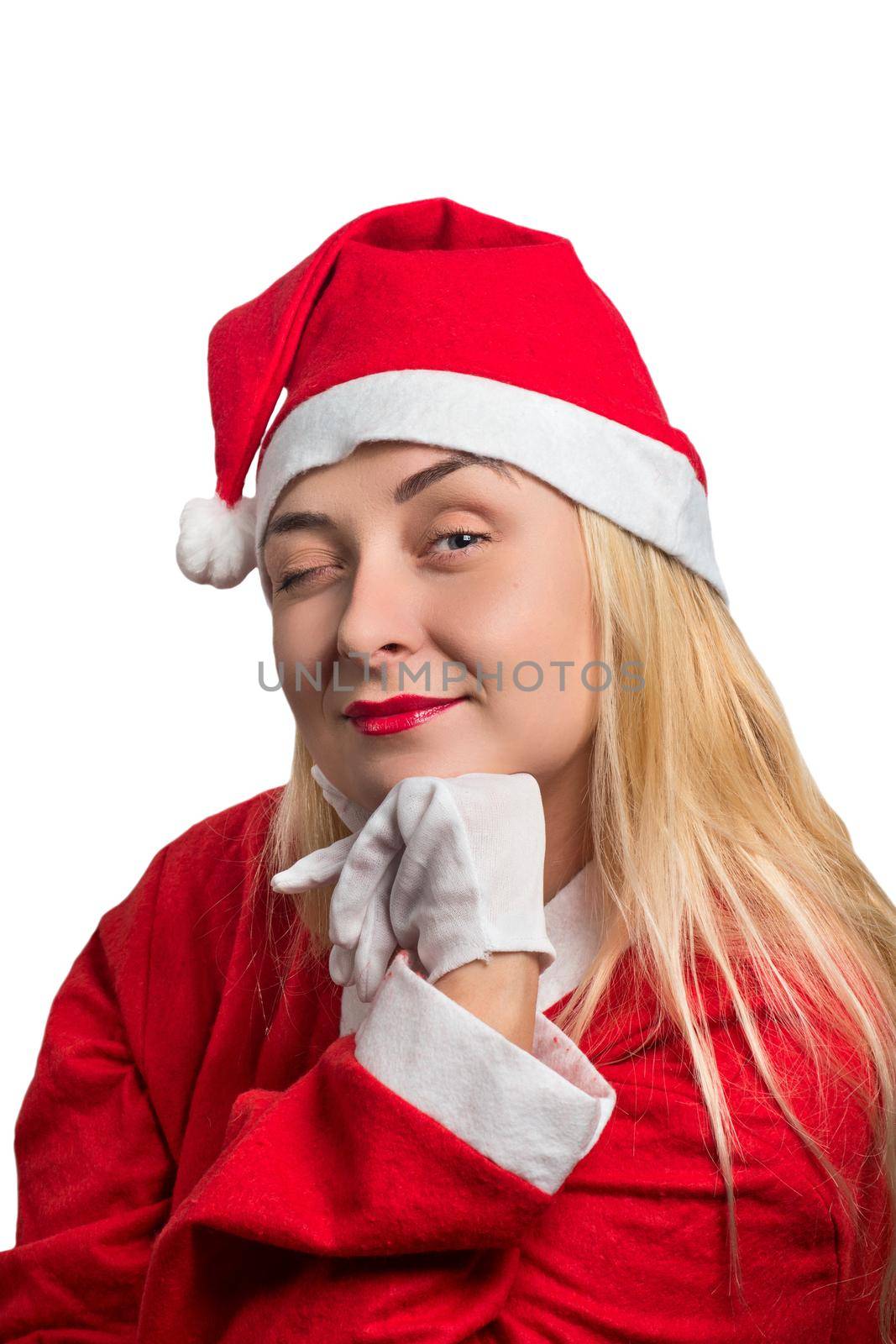Portrait of a girl in a red Santa suit winking on white background