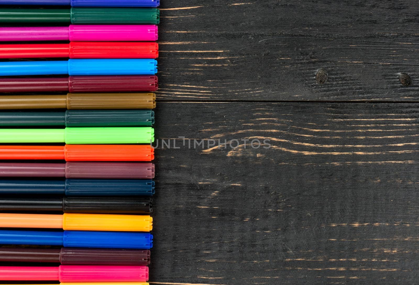 Lot of colorful markers on wooden background, top view