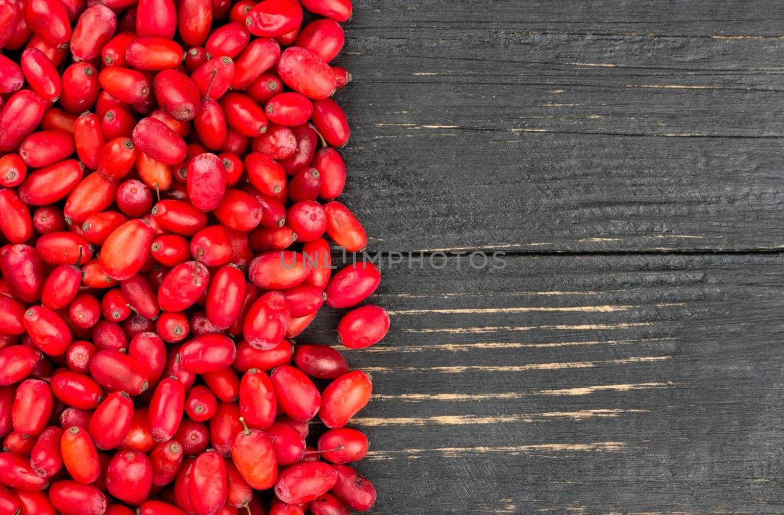 Scattered fresh barberry on a wooden background top view