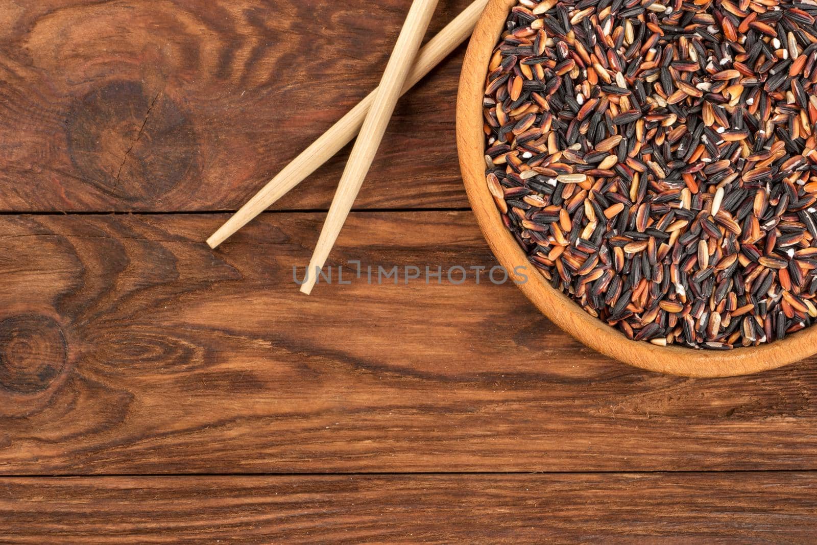 Wild rice in a bowl with chopsticks on the table top view