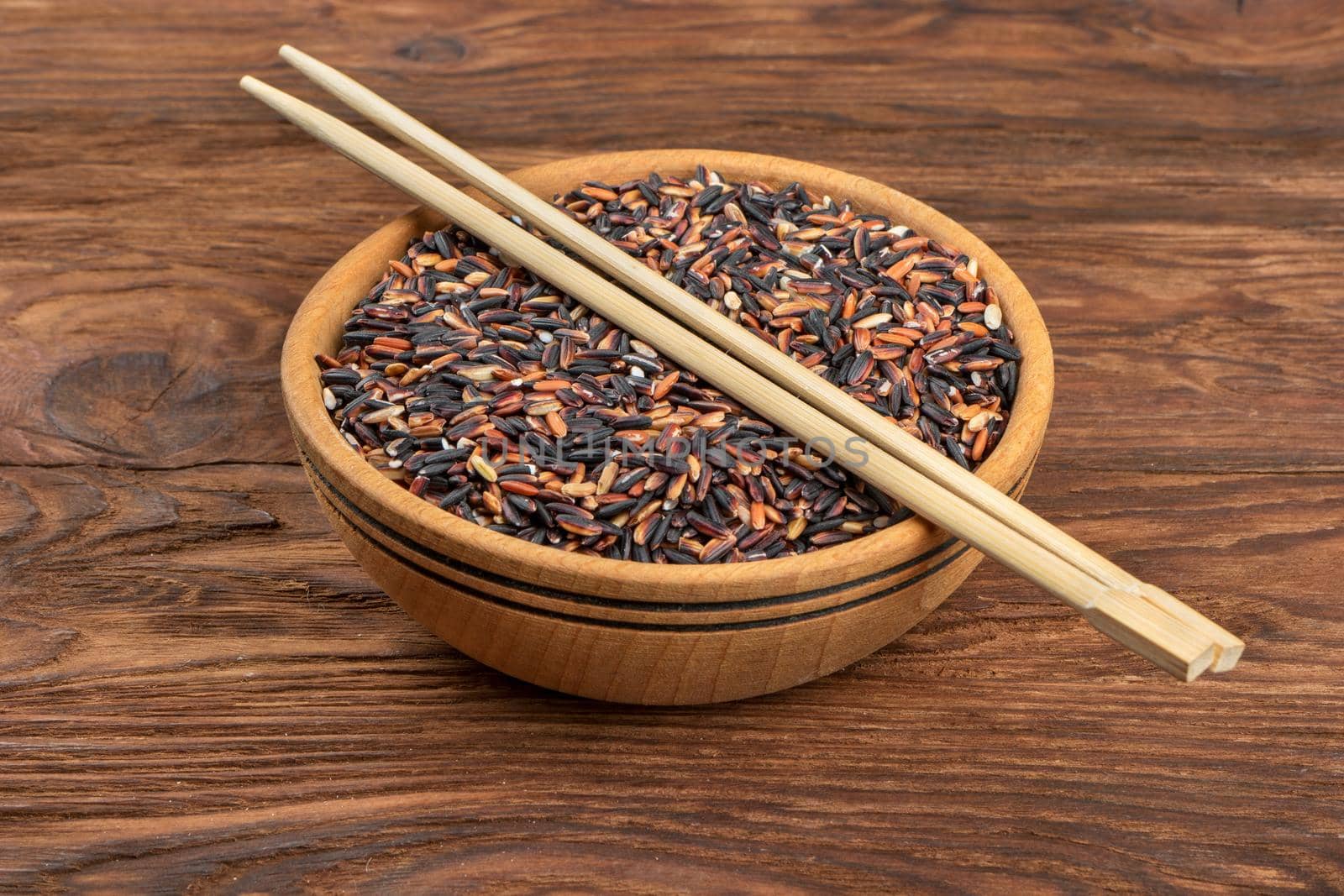 Wild rice in a bowl with chopsticks on the table