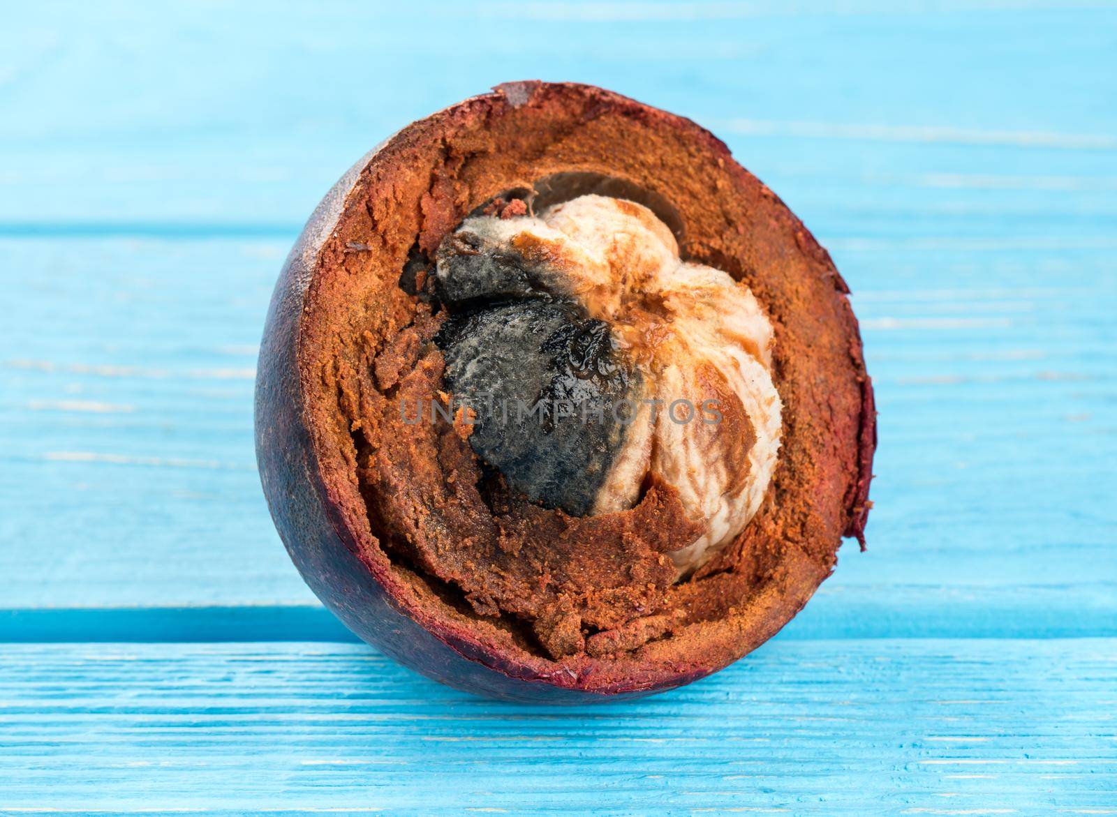 Half of rotten fruit mangosteen on a blue table