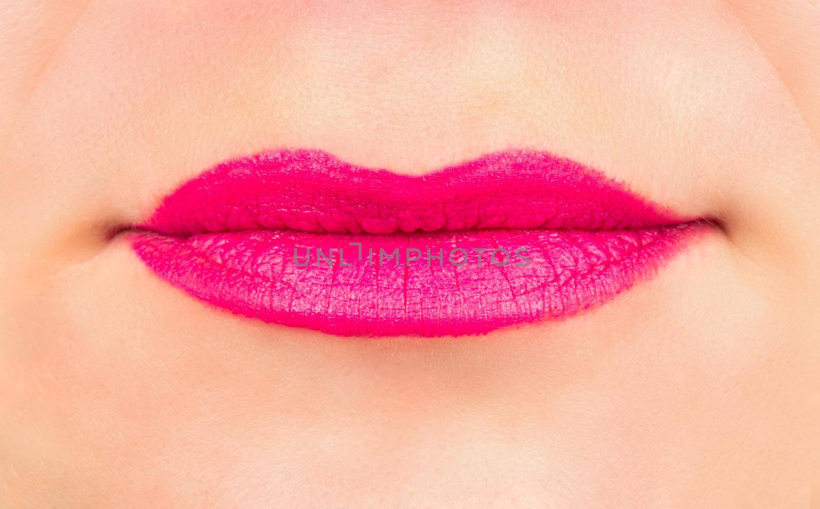 Female lips with pink lipstick close up