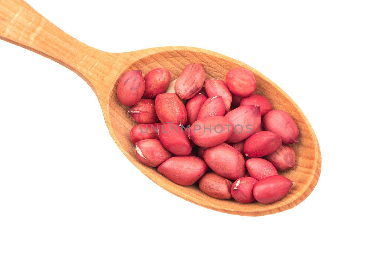 Peanut kernels in a wooden spoon on a white background