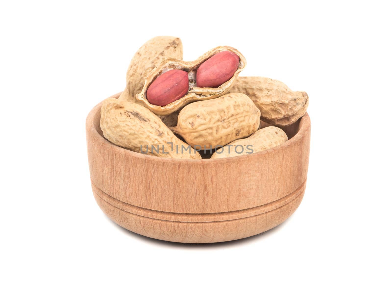Dry peanuts in shell in a wooden bowl on a white background