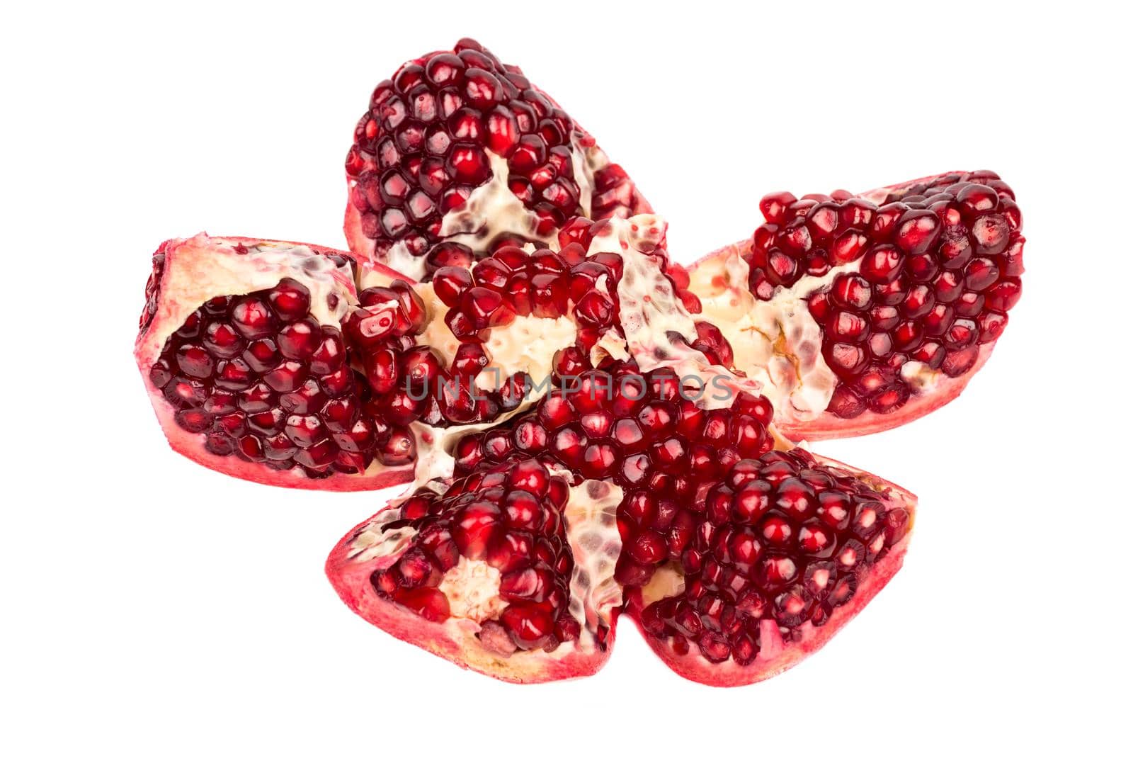 Fresh pomegranate cut into five pieces on a white background