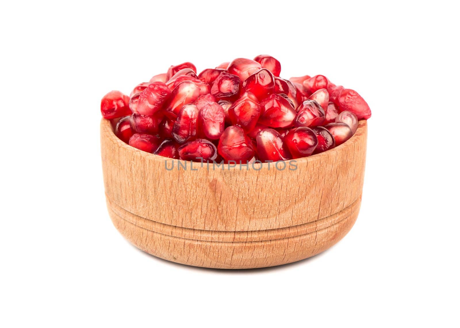 Fresh pomegranate seeds in a small wooden bowl isolated on white background