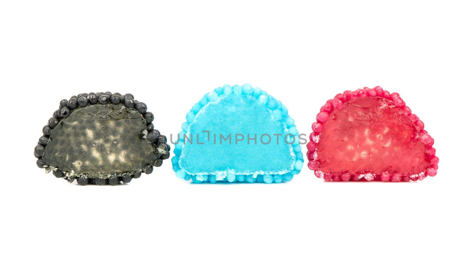 Three halves of multicolored berry jelly sweets on a white background