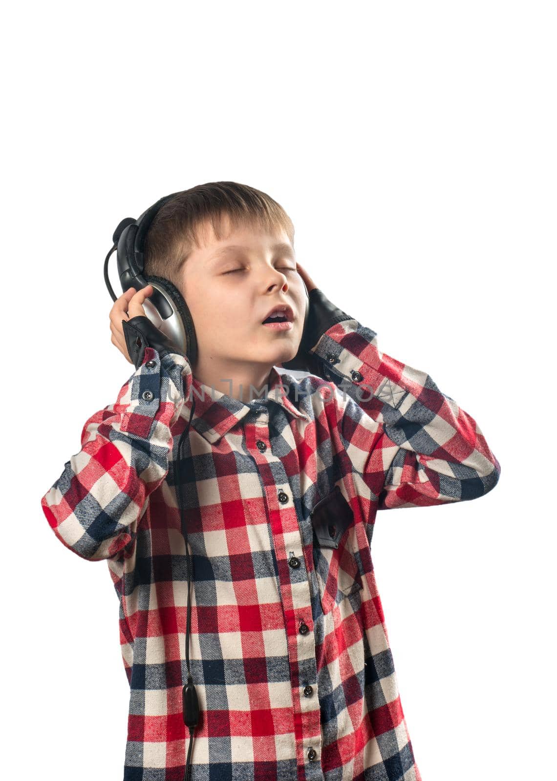 Little boy enjoys music in headphones over white background