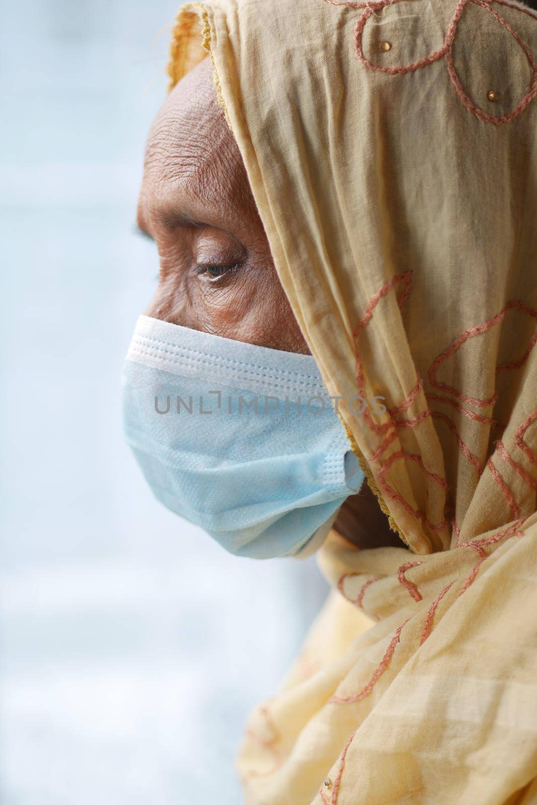 portrait of an old woman wearing a surgical mask,