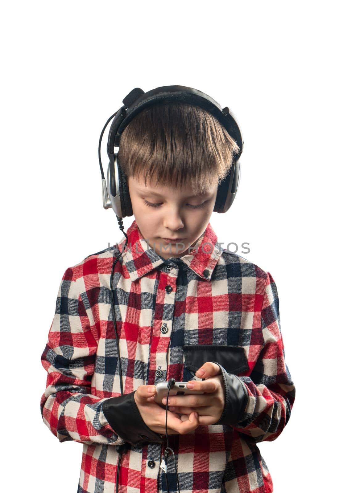 Boy listening to music on headphones with a smartphone on a white background